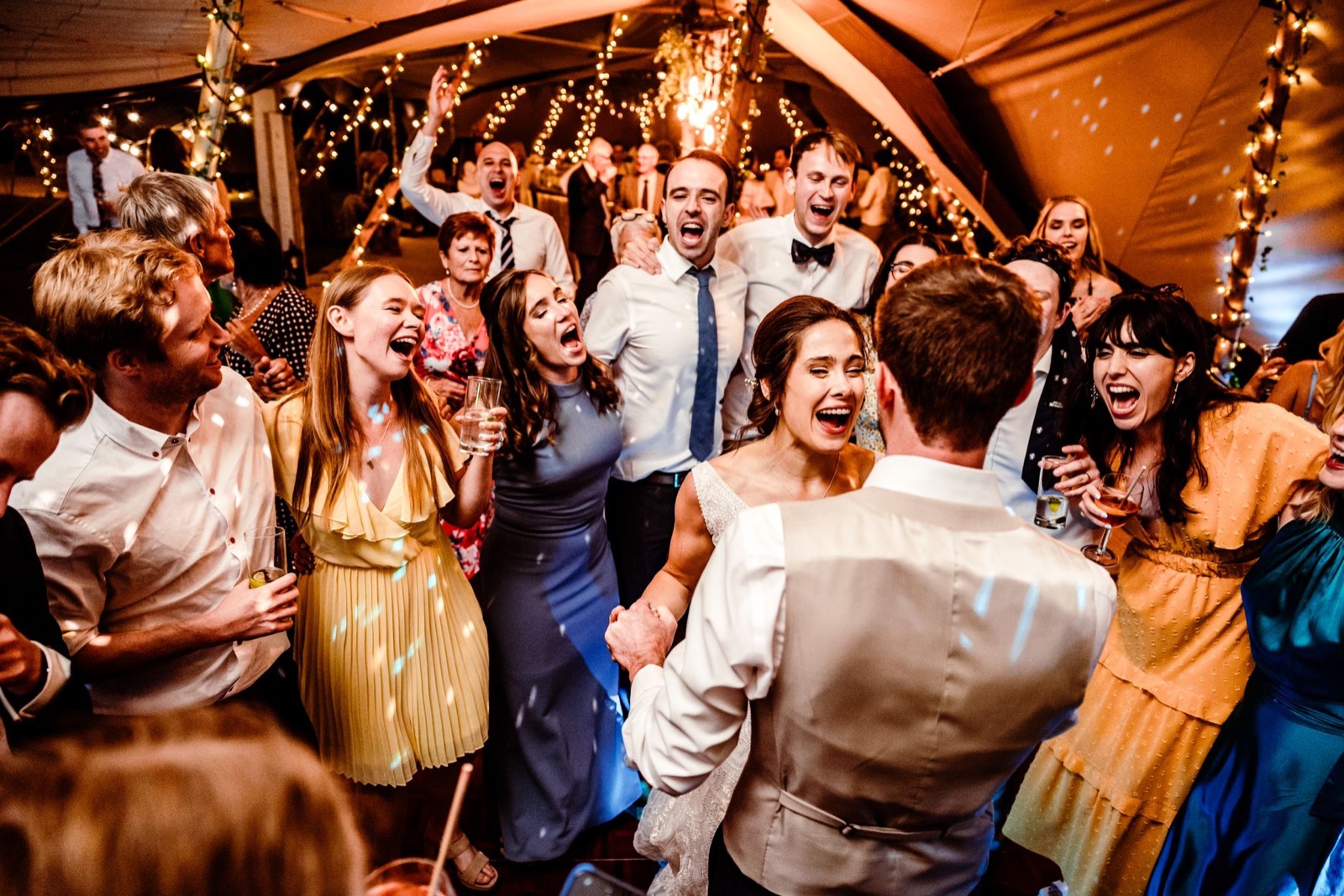 Wedding guests singing and dancing on a packed dancefloor